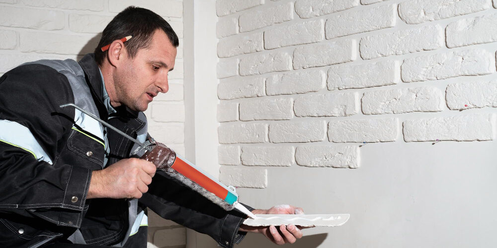 master-applies-glue-tiles-facing-house-master-builder-decorates-walls-apartment-finishing-building-with-modern-materials